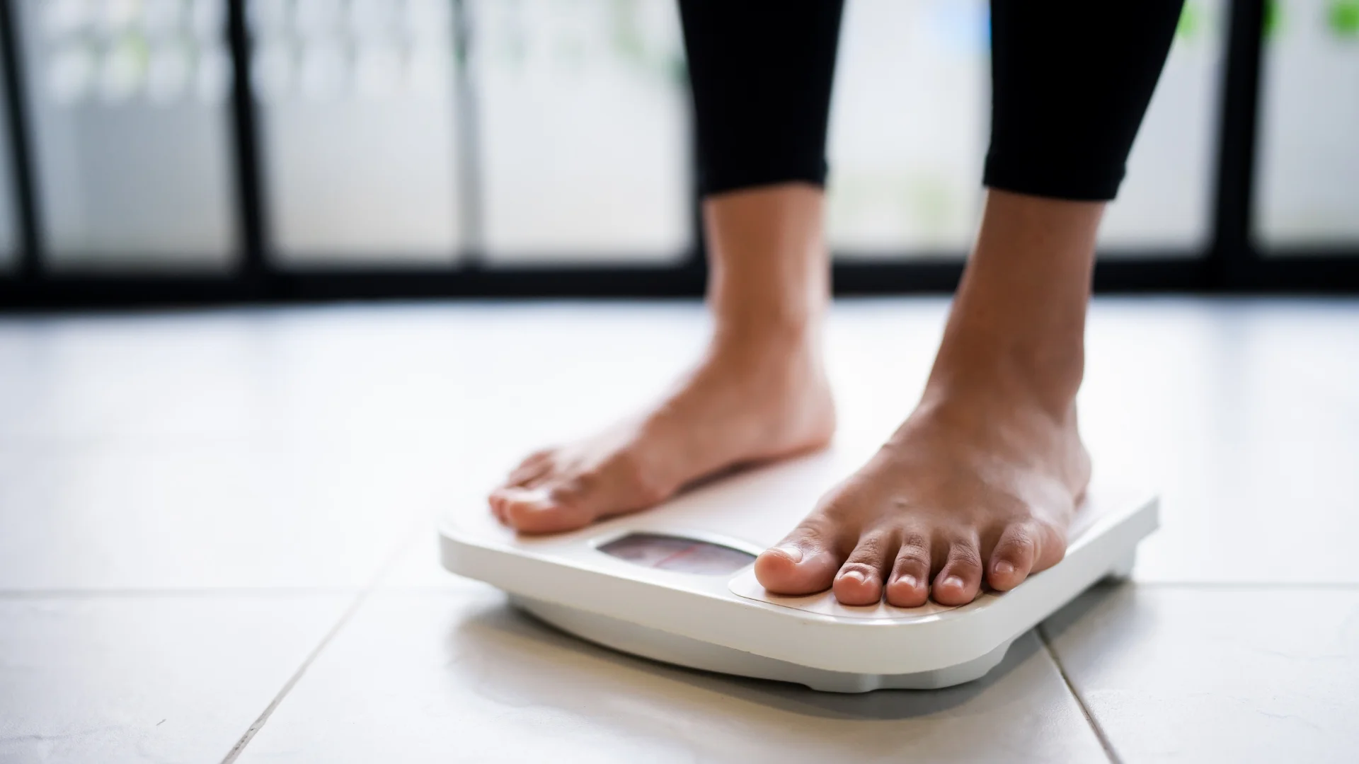 A person stepping onto a scale during a physician-supervised weight loss program